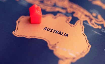 Toy house on a map at the location of Australia