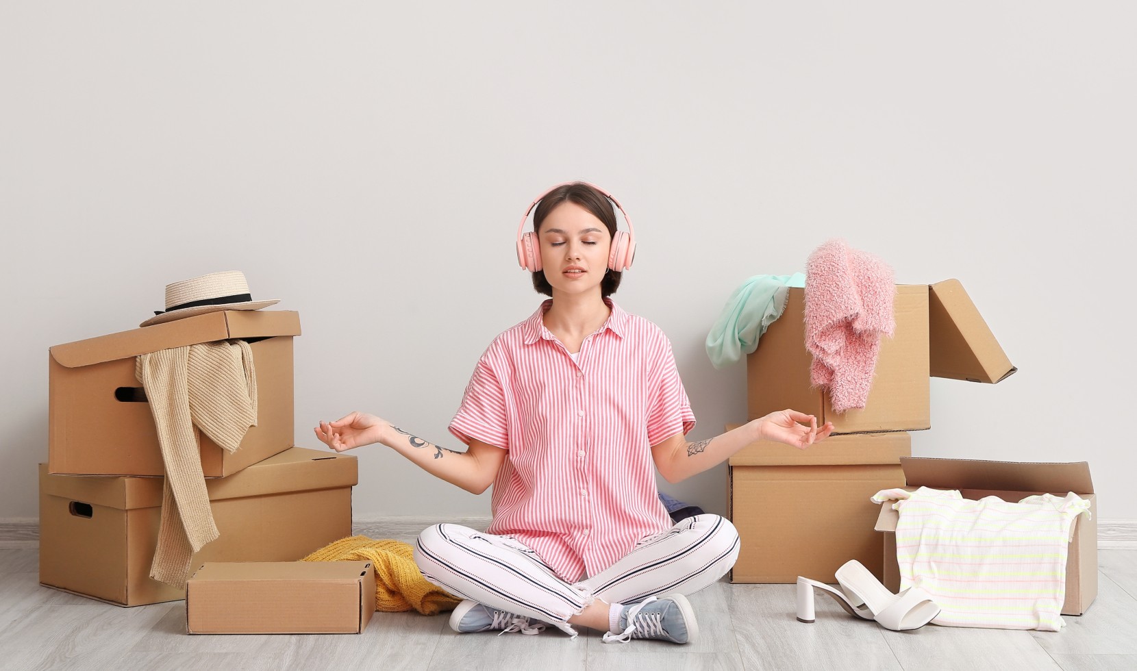 Woman meditating surrounded by moving boxes