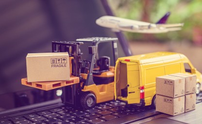 Miniature forklift with a box labeled fragile near a delivery van and airplane
